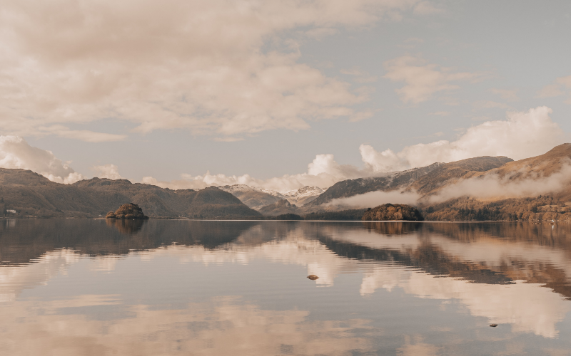 Lake District landscape scene, mountains reflecting on a lake with a cloud filled sky